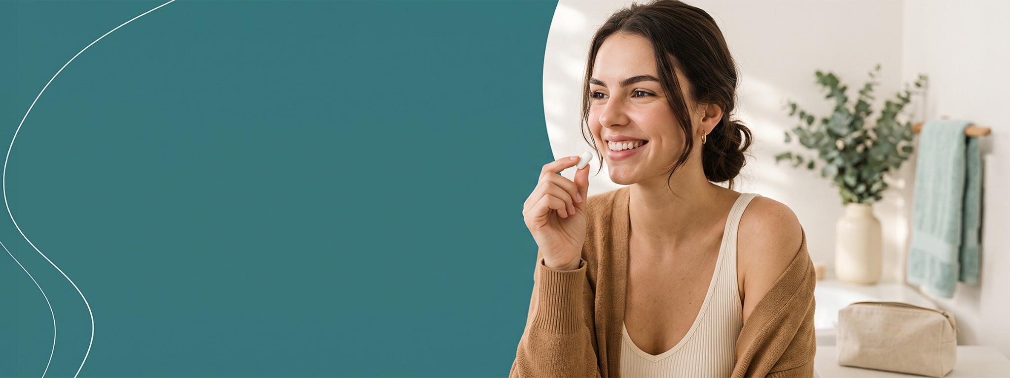 Woman smiling while holding a piece of gum in a bright bathroom